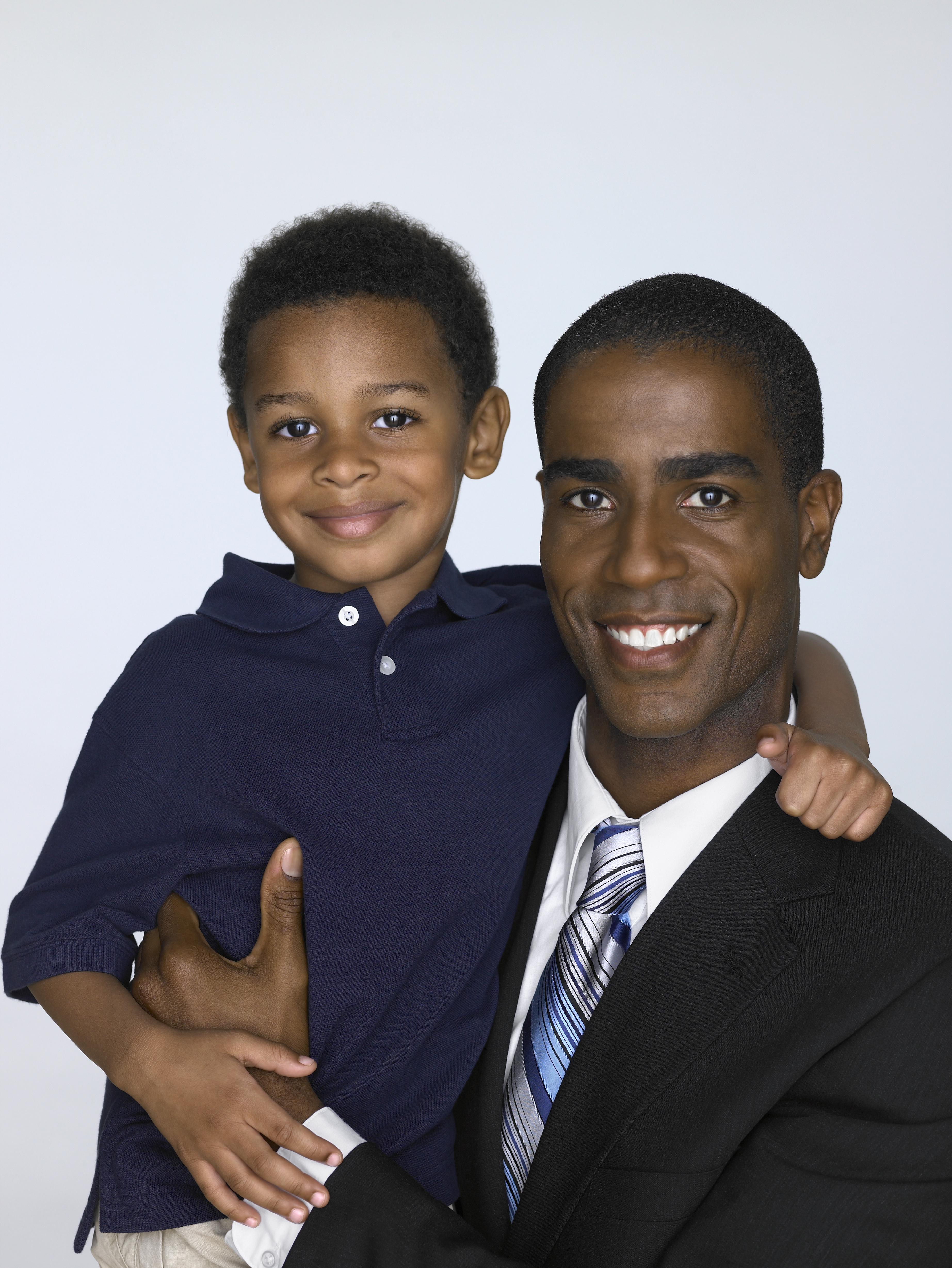 Father holding son (3-5), portrait