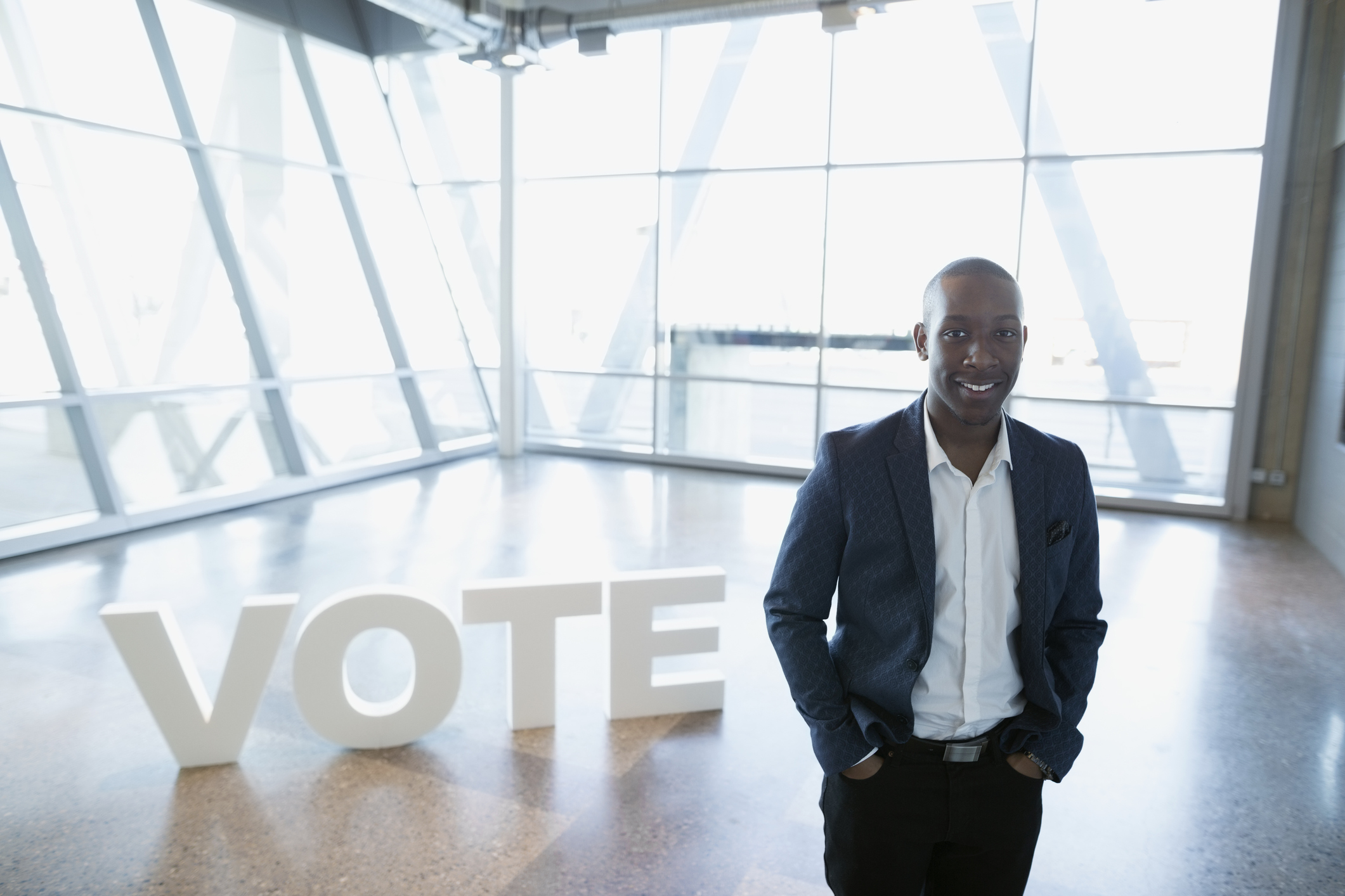 Portrait smiling young businessman near Vote text