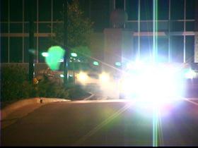 Police cars speeding down road at night