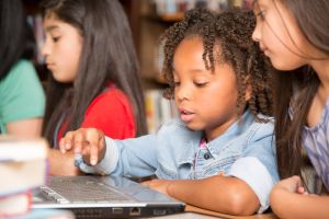Elementary-age children learn computer coding in school.