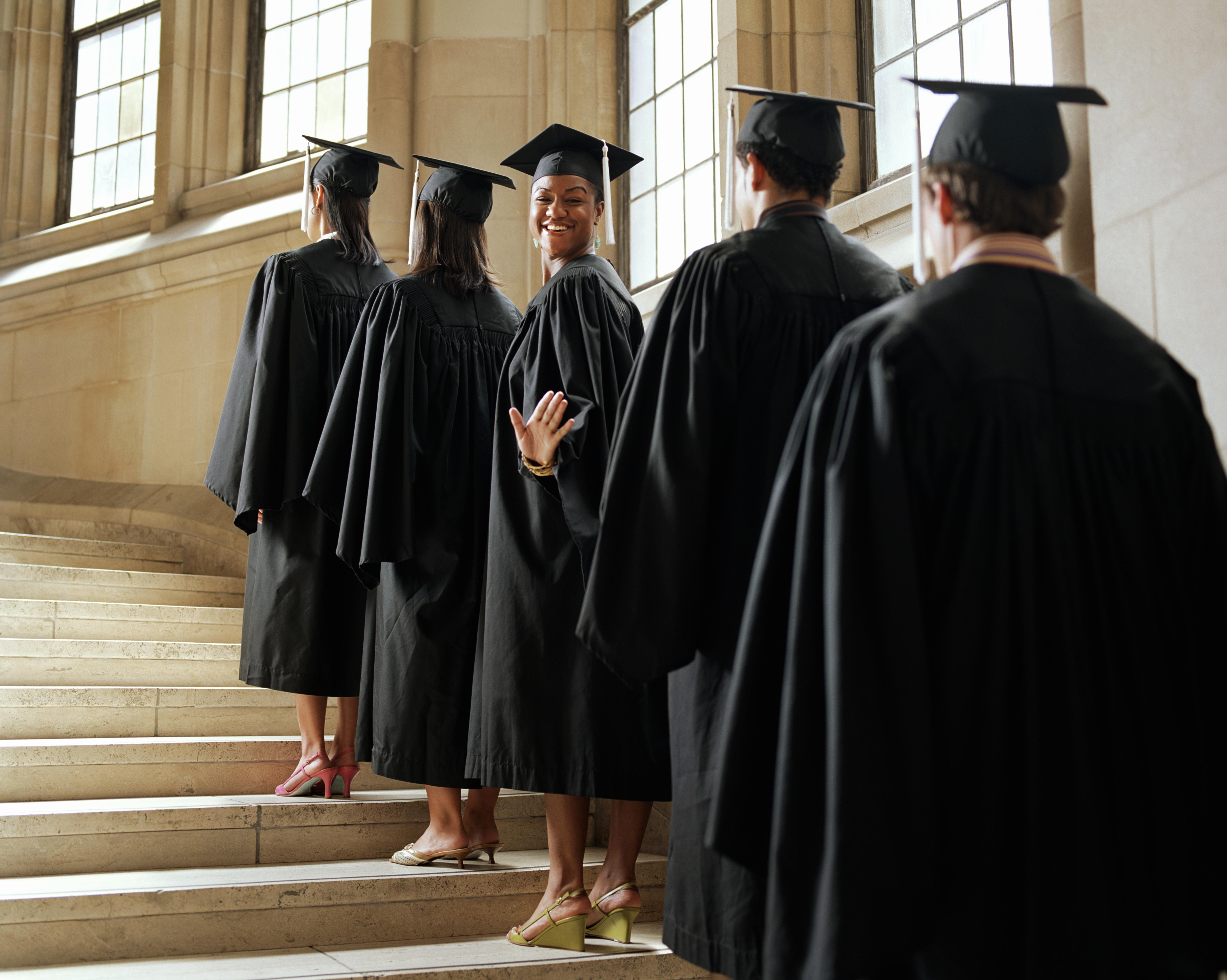 Graduate in line climbing stairs, turning to wave