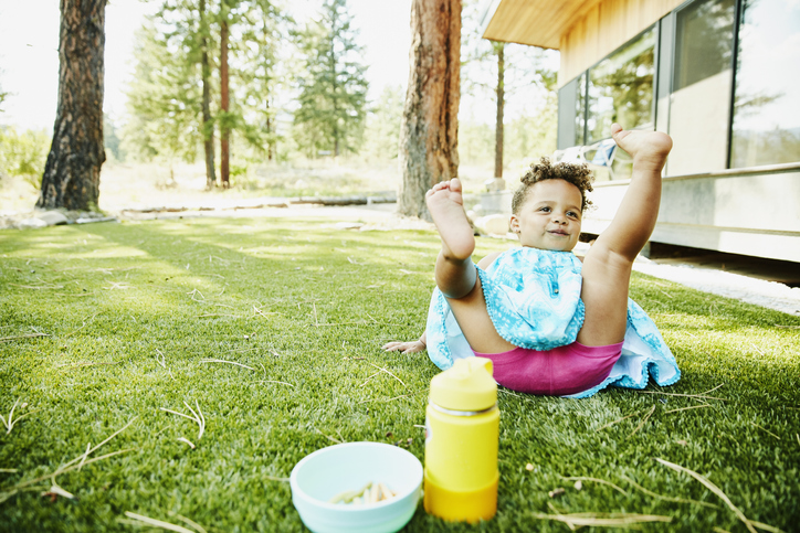 Toddler girl falling down in front yard of vacation home