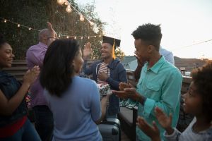 African American family celebrating graduation on summer deck