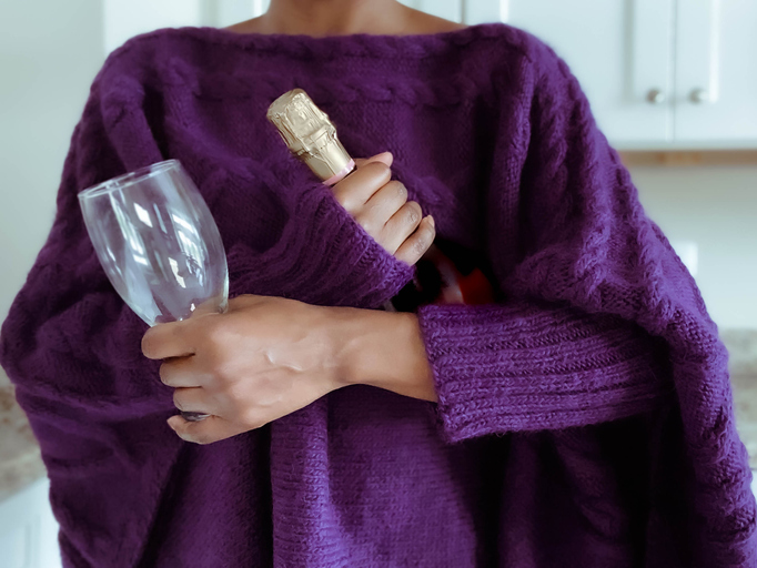Woman Holds Bottle of Wine and Glass